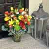 Colorful mixed bouquet in a glass vase with yellow, orange, red, and white flowers