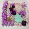 Floral gift box with pink and lavender roses and purple orchids around candy boxes