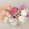 Pink and white floral arrangement in a white vase with peach accents
