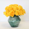 Yellow roses in a green glass vase