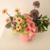 Pink roses and peach gerbera daisies in a pink vase