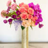Pink roses and purple orchids in a gold vase