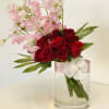 Red roses and pink sweet peas in a clear glass vase