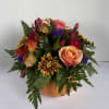 Mixed bouquet of roses and chrysanthemums in an orange pumpkin container