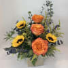 Orange roses and yellow sunflowers in a square vase