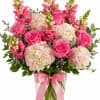 A lush everyday arrangement featuring elegant pink roses, cloud like hydrangea blooms