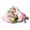 Hand-tied bouquet of pink and white roses with baby's breath wrapped in pink paper and ribbon.