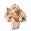 Pink and cream flower arrangement in a round hat box with ribbon
