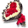 Bouquet of red and white roses wrapped in dark paper with a red ribbon
