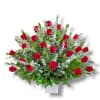 Red roses arranged in a white vase with mixed greenery