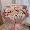 Pink and white bouquet of roses and carnations wrapped in pink paper