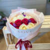 Bouquet of pink, white, and purple roses wrapped in paper
