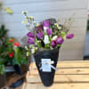 Purple and white tulips in black wrap with small white blossoms