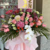 Large pink floral standing arrangement with roses and white orchids