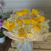 Yellow roses with baby's breath and a jeweled tiara in wrapped bouquet