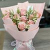 Pink rose bouquet with small white daisies wrapped in pale pink paper