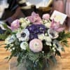 Round bouquet with pink orchids, white anemones, and purple hydrangea in a vase