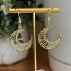 Pair of gold crescent moon earrings on a display stand