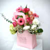 Pink and white mixed flower arrangement in a pink gift bag