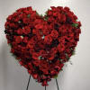 Heart-shaped arrangement of red roses on a stand