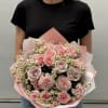 Pink rose bouquet with small white daisies wrapped in pink paper