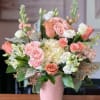 Pink and white rose bouquet in a pink vase
