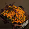 Large bouquet of yellow sunflowers wrapped in dark paper with ribbon