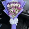 Bouquet of purple, pink, and white tulips wrapped in lavender paper