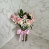 Pink roses in a glass vase with a pink ribbon