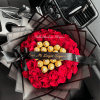 Round bouquet of red roses with gold-wrapped chocolates and black ribboned wrapping on a car seat.