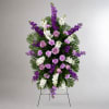 Standing floral spray with purple and white flowers on an easel