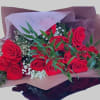 Bouquet of red roses with baby's breath and greenery in pink and burgundy wrap