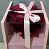 Boxed bouquet of deep red roses tied with a pale pink ribbon