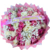 Large round bouquet of pink and cream roses with white baby's breath and a Feliz Cumpleaños ribbon.
