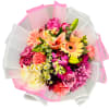 Mixed bouquet of pink, peach, and yellow flowers wrapped in white and pink paper