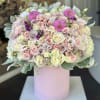 Large pastel bouquet of roses and pink blooms in a pink cylinder box