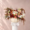Mixed roses and small daisies arranged in a white pumpkin vase