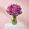 Pink and purple bouquet of roses, carnations, and alstroemeria in a glass vase