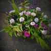 Low garden-style arrangement of lavender roses with bright pink accents and airy greenery