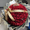 Round bouquet of red roses with a gold ribbon and tiara