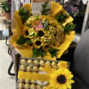 Sunflower bouquet with yellow wrapping and a box of chocolates tied with ribbon