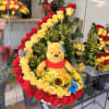 Large rose arrangement with a Winnie the Pooh plush and yellow flowers