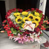 Large bouquet of red roses, sunflowers, and pink lilies in a box