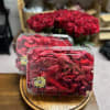 Red rose bouquet in clear plastic boxes on a wooden tray