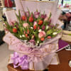 Bouquet of pink, purple, and orange tulips with roses wrapped in pink paper