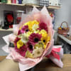 Bouquet of pink, yellow, and white gerbera daisies wrapped in pink paper