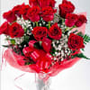 Bouquet of red roses with baby's breath in a clear glass vase