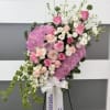 Standing floral spray with pink and white flowers on an easel
