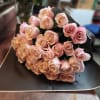 Bouquet of pale pink roses wrapped in black paper