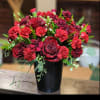 Red roses and carnations arranged in a black vase